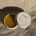 Wilde Aroma spearmint healing lip balm on fabric.