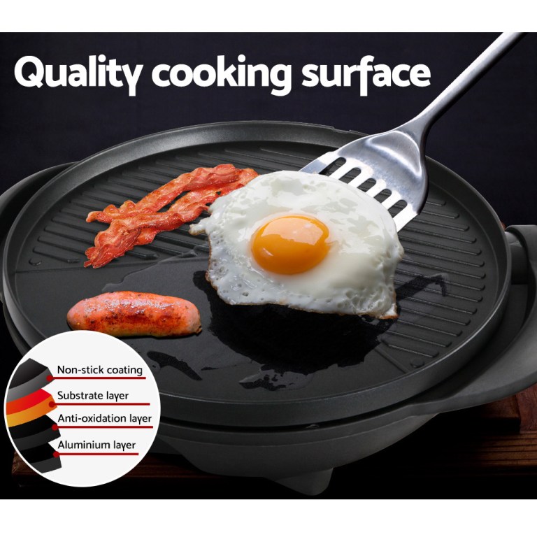 Non-stick grill with fried egg, bacon, sausage.