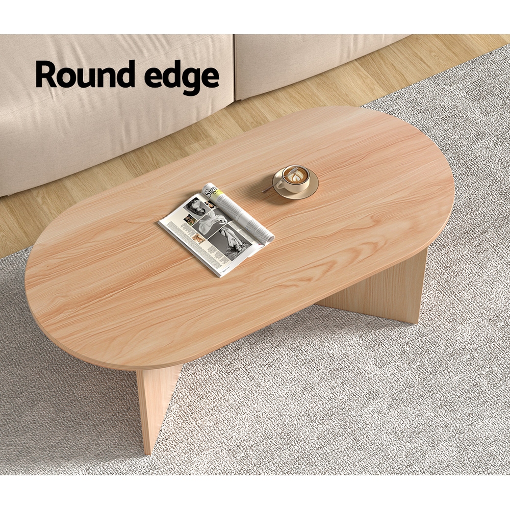 Round edge wooden coffee table with magazine, candle.