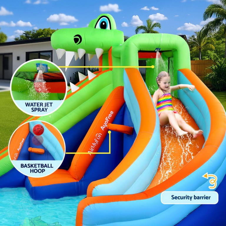 Child sliding on inflatable water slide with features.