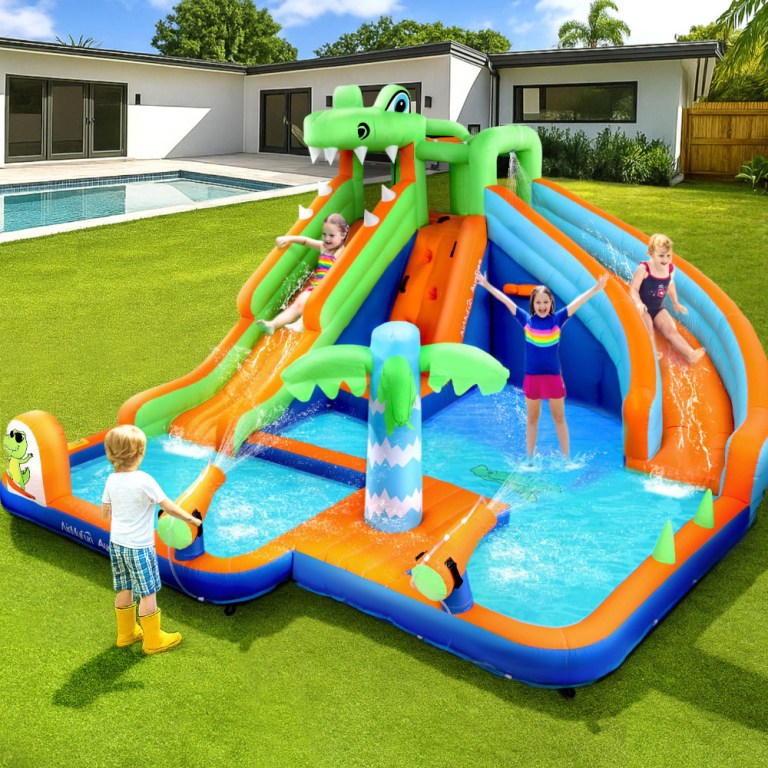 Kids playing on inflatable water slide in backyard.