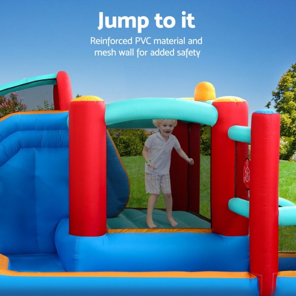 Child playing in colourful inflatable bouncer outdoors.