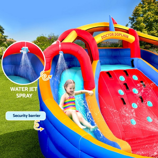 Child sliding on colourful inflatable water slide.