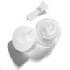 Open jar of white face cream with applicator.