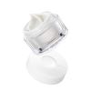 Luxury skincare cream in clear jar, lid open.