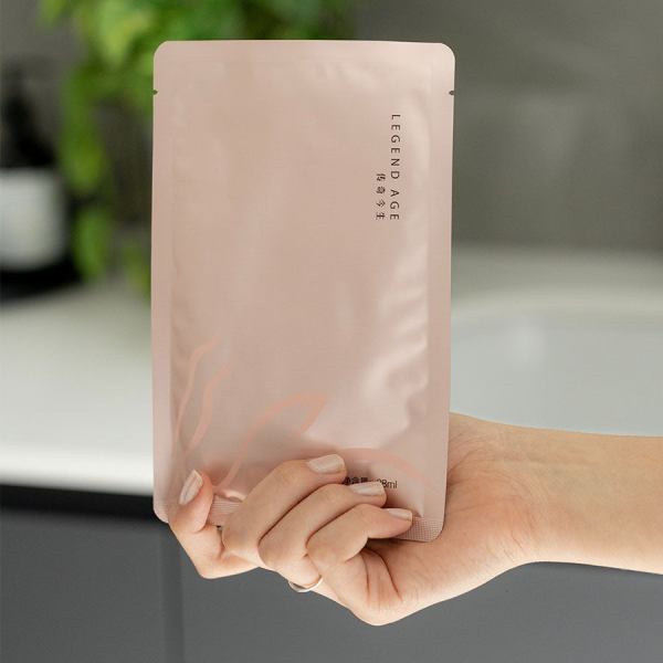 hydrating face mask | super hydration | silky skin & fine pore Person holding pink skincare product package.