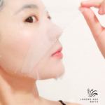 Woman applying face mask skincare product.