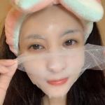 Woman applying a face mask with headband.