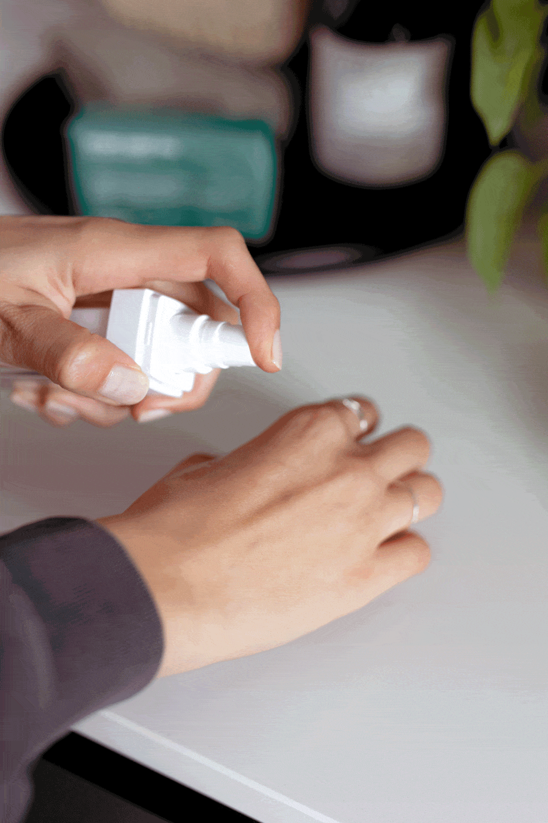 Applying spray moisturiser on hands, skincare routine.