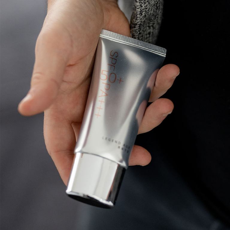 Hand holding SPF sunscreen tube