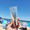 Person holding sunscreen at sunny beach