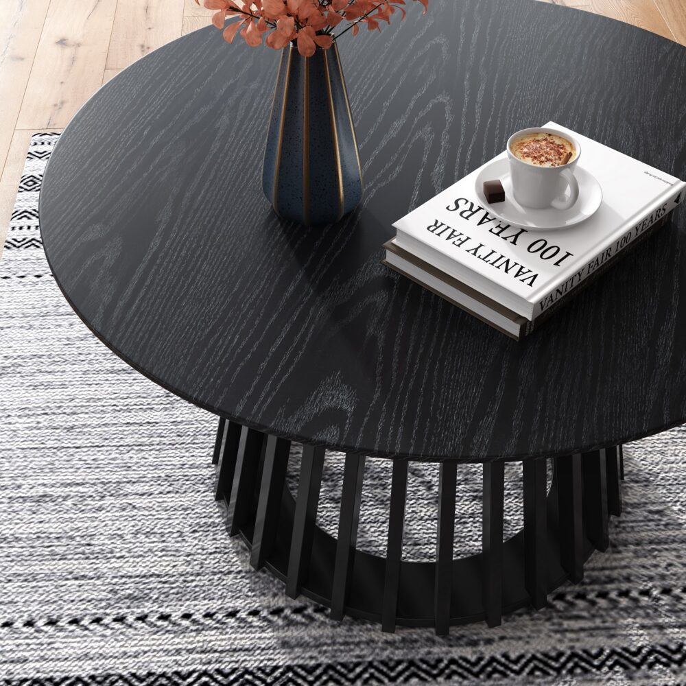 Round black coffee table with magazines and cappuccino.