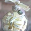 Clear ornament with paper scrolls and ribbon.