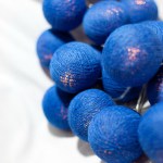 Blue decorative string lights on white background.