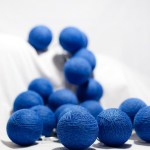 Blue yarn balls scattered on white background.