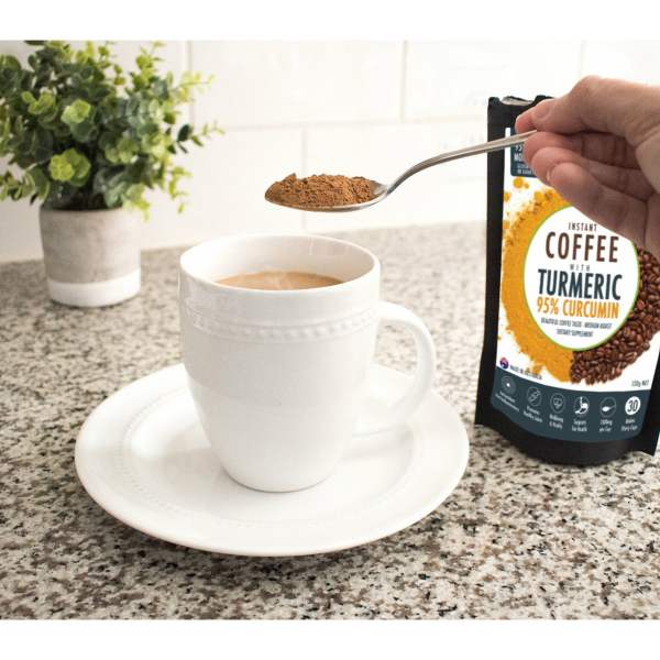 Cup of coffee with turmeric on a kitchen counter.