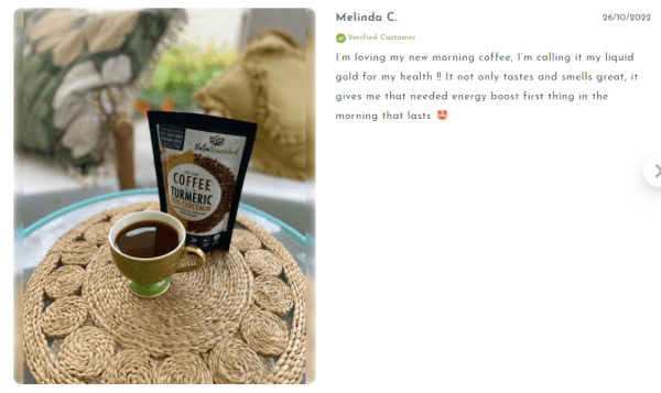 Cup and pack of turmeric coffee on table