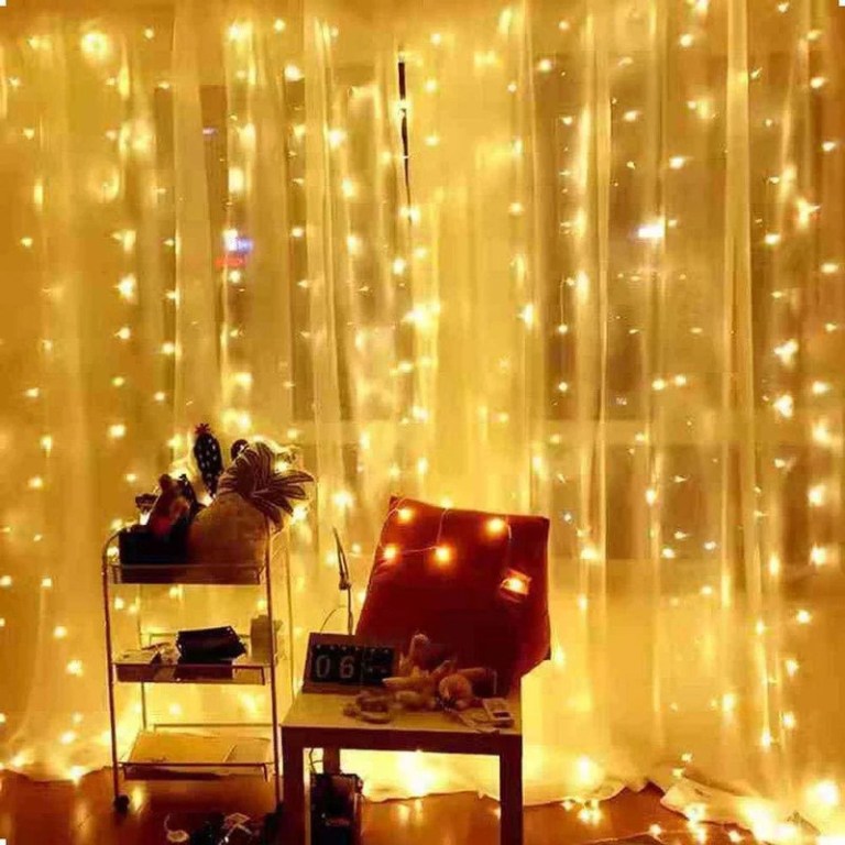 Cosy room with warm fairy lights on curtains.