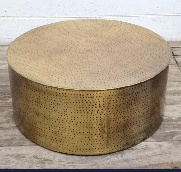 Round brass coffee table with textured surface.