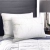 Two white pillows on a neatly made bed.