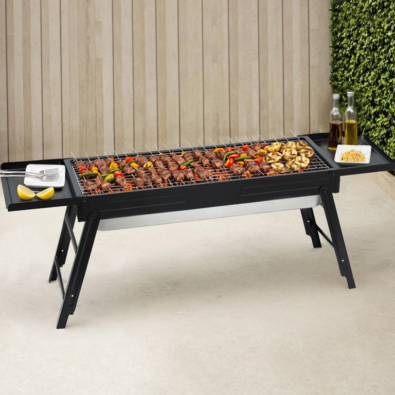 Portable barbecue grill with skewers and condiments.
