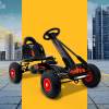 rigo kids pedal go kart ride on toys racing car rubber tyre black Black pedal go-kart with red wheels in cityscape.