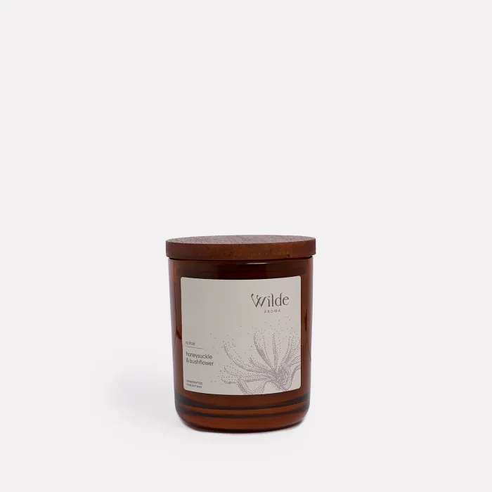 Amber candle with wooden lid, labelled honeysuckle bushflower.