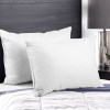 Two white pillows on modern bed with lamp.