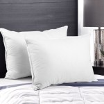 Two white bed pillows on quilted bedspread