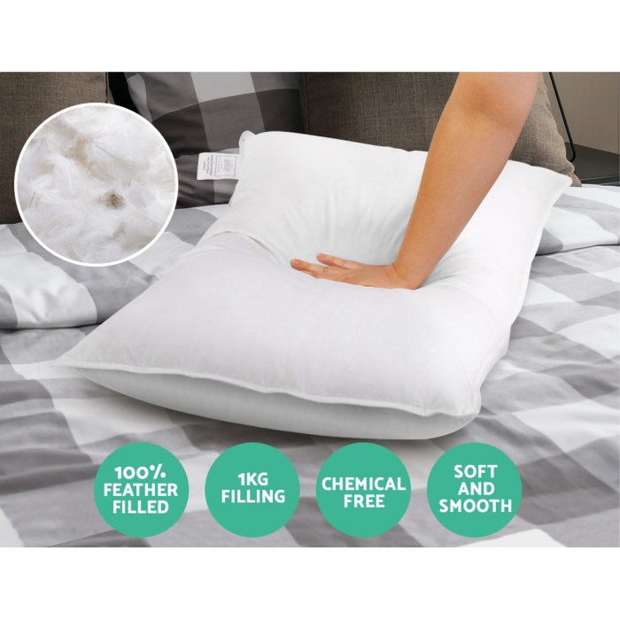 giselle bedding goose feather down pillow twin pack Hand pressing feather-filled pillow on bed.