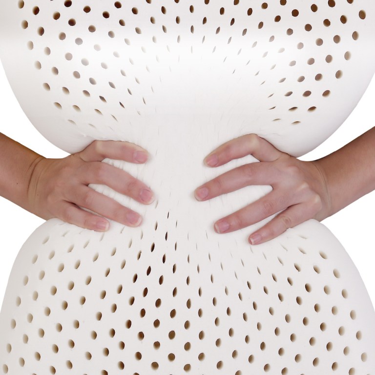 Hands squeezing perforated foam object.