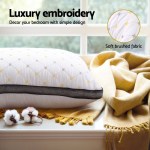 Luxury embroidered pillow and soft blanket in bedroom.