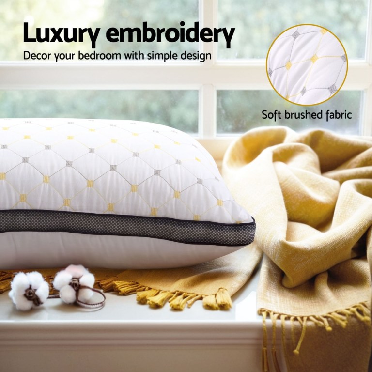 Luxury embroidered pillow and soft blanket in bedroom.