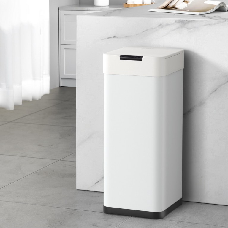 Automatic kitchen bin next to counter.