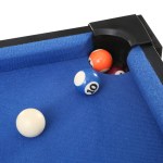 Pool balls on blue table near pocket