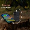 Portable power bank charging smartphone outdoors.