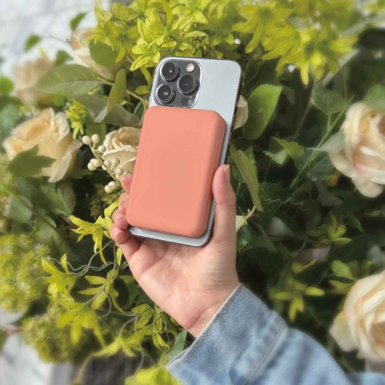 laser 5000mah magnetic wireless power bank peach Hand holding smartphone with floral background