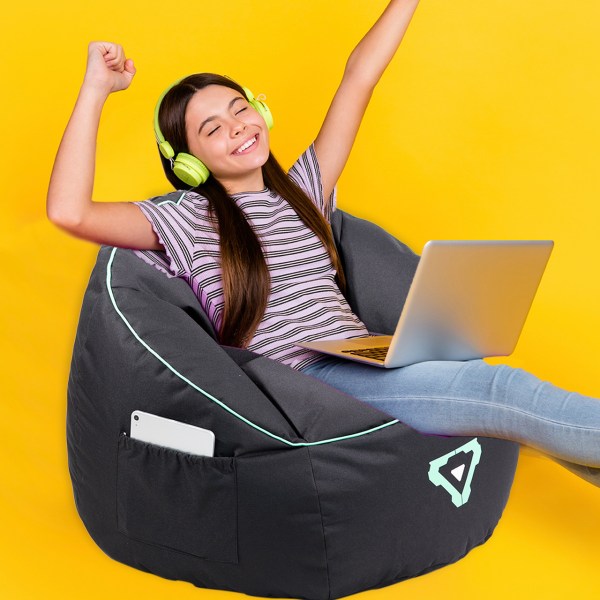 Happy girl relaxing with laptop, wearing headphones.