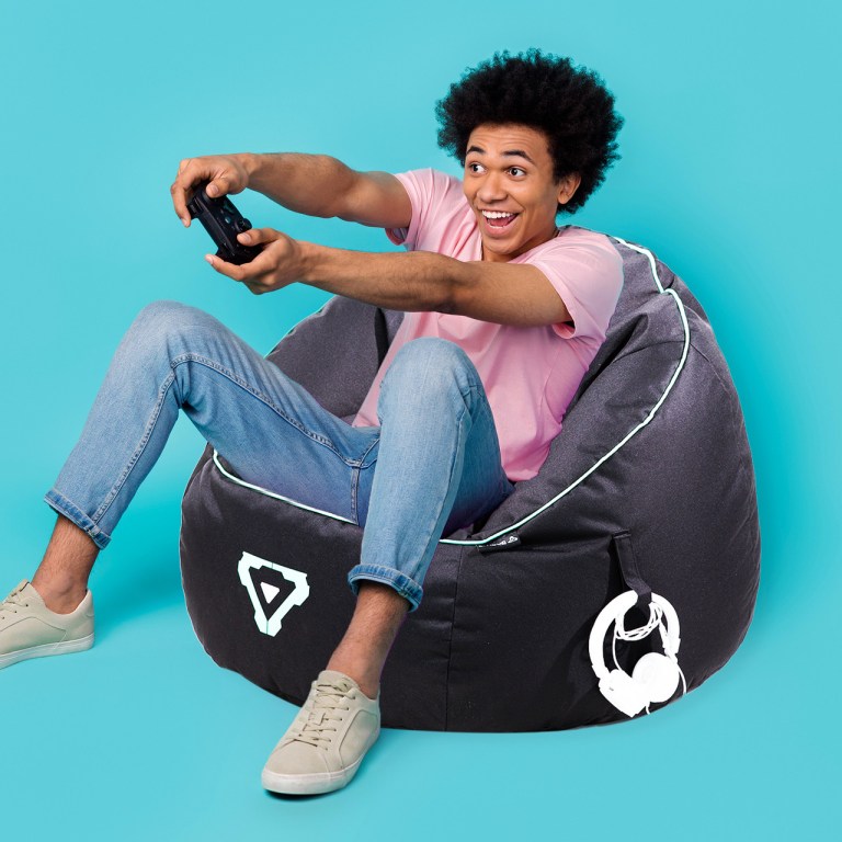 laser gaming bean bag with pocket & headphone strap Person gaming on a bean bag, excited expression.