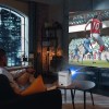 Man watching football game via projector at home.