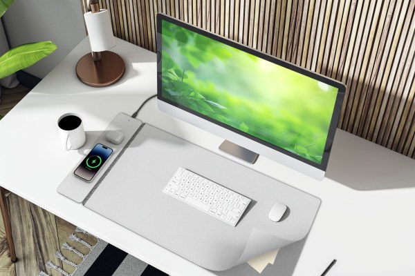 laser wireless charging desk mat grey Modern minimalist desk with computer and wireless charging.