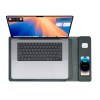 Laptop with smartphone and AirPods on charging pad.