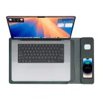 Laptop with smartphone and AirPods on charging pad.