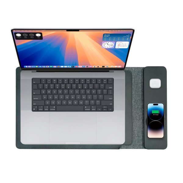 Laptop with smartphone and AirPods on charging pad.