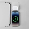 Phone and earbuds wirelessly charging on pad.