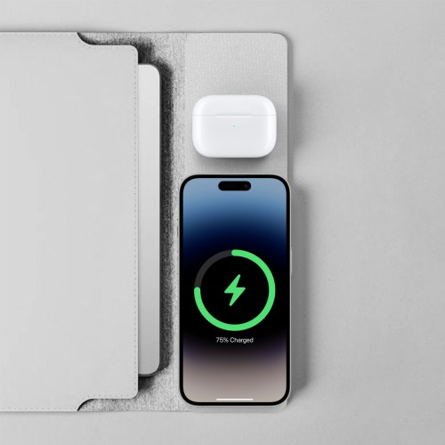 Phone and earbuds wirelessly charging on pad.