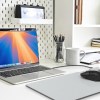 Modern office desk with laptop and stationery.