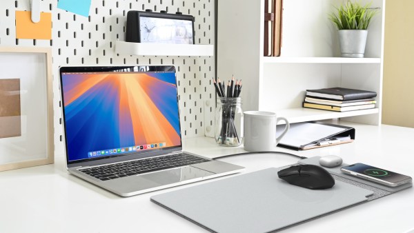 Modern office desk with laptop and stationery.