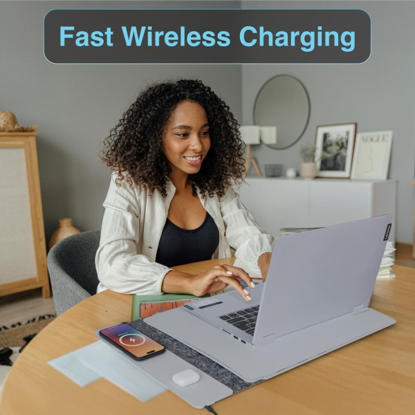 Person using laptop with wireless charging pad.