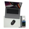 Laptop, mouse, and charging phone on desk mat.